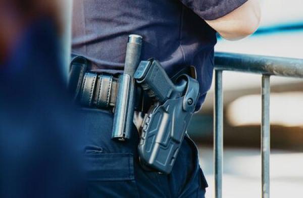 A security officer carries a gun on his belt